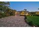 Charming home featuring manicured lawn, paver driveway, landscape lighting, and lush greenery at 13 Bayhead Ln, Osprey, FL 34229