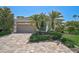 This charming home features a paver driveway, mature palms, and lush landscaping at 13 Bayhead Ln, Osprey, FL 34229