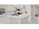 Elegant kitchen with marble countertops, tiled floors, and white cabinetry provides great style at 13 Bayhead Ln, Osprey, FL 34229