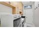 Bright laundry room with cabinetry, appliances, and a granite countertop sink at 13 Bayhead Ln, Osprey, FL 34229