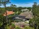Aerial view of a home with a screened pool enclosure and lush landscaping at 13 Bayhead Ln, Osprey, FL 34229