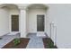 Close-up of townhome entrances with dark doors, grey paver walkway, and neutral paint at 14783 Lyla Ter, Bradenton, FL 34211