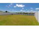 Large, grassy backyard featuring a pond view and secure fencing, perfect for outdoor activities at 15118 Agave Grove Pl, Bradenton, FL 34212