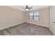 Bedroom with neutral color palette, plush carpeting, ceiling fan, and a window for natural light at 15118 Agave Grove Pl, Bradenton, FL 34212