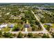 Overhead view of the property, situated amidst trees and greenery, with a road nearby at 158 Chickering St, Port Charlotte, FL 33954