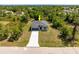 Areal view of home in a wooded area with a long concrete driveway leading to the front door at 158 Chickering St, Port Charlotte, FL 33954
