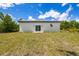 A large, grassy backyard featuring a sliding glass door that leads to the home's interior at 158 Chickering St, Port Charlotte, FL 33954