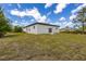 Rear exterior view with sliding glass door, small window, and a well-maintained grassy yard at 158 Chickering St, Port Charlotte, FL 33954