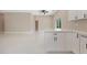 Kitchen with white cabinets and marble counter overlooking living area with white tiled floors at 158 Chickering St, Port Charlotte, FL 33954