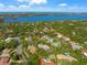 A scenic aerial view captures a home nestled among trees with a glimpse of the bay at 1693 Landings Ln, Sarasota, FL 34231