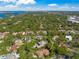 A panoramic aerial view shows a neighborhood nestled among lush greenery, with the bay in the distance at 1693 Landings Ln, Sarasota, FL 34231