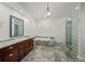 Bathroom with a soaking tub, glass block shower, and marble-topped vanity at 1693 Landings Ln, Sarasota, FL 34231