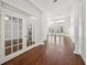 Bright living room featuring hardwood floors, French doors leading to a pool, and neutral decor at 1693 Landings Ln, Sarasota, FL 34231
