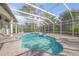 Inviting screened-in pool and spa featuring a brick paved deck and multiple access points to the home at 1693 Landings Ln, Sarasota, FL 34231