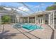 Inviting screened-in pool and spa featuring a brick paved deck and multiple access points to the home at 1693 Landings Ln, Sarasota, FL 34231