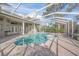 Inviting screened-in pool and spa featuring a brick paved deck and multiple access points to the home at 1693 Landings Ln, Sarasota, FL 34231