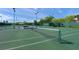 Well-maintained tennis court with green surface and shaded benches at 1693 Landings Ln, Sarasota, FL 34231