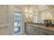 Bright bathroom with window, large mirror, modern lighting, and gray vanity at 1755 7Th St, Sarasota, FL 34236