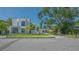 Stunning modern home with clean lines, palm trees, and lush landscaping in front of a neighboring home at 1755 7Th St, Sarasota, FL 34236