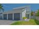 Modern home exterior with a three-car garage, clean lines, and landscaped front yard at 1755 7Th St, Sarasota, FL 34236