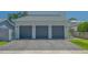 A three-car garage with gray doors and a paver driveway offers ample parking space at 1755 7Th St, Sarasota, FL 34236