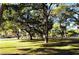 Green park landscape featuring mature shade trees casting shadows across a manicured lawn at 1755 7Th St, Sarasota, FL 34236