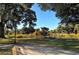 Scenic park view showcasing a calm lake framed by trees, shrubbery, and a park bench at 1755 7Th St, Sarasota, FL 34236