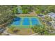 Aerial view of three well-maintained tennis courts surrounded by lush greenery, offering residents a recreational space at 1755 7Th St, Sarasota, FL 34236