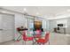 Bright and airy dining room with a glass-top table, red chairs, and modern decor at 1765 7Th St, Sarasota, FL 34236