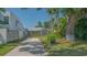 Charming single-story home with red shutters, lush greenery, and a long driveway at 1765 7Th St, Sarasota, FL 34236