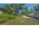 The front yard featuring a driveway, green grass, lush landscaping and a large tree at 1765 7Th St, Sarasota, FL 34236