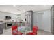 Modern kitchen with stainless steel appliances, grey cabinetry, and a glass-top table with red chairs at 1765 7Th St, Sarasota, FL 34236
