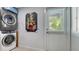 Laundry room with modern washer and dryer, utility sink, and natural light from a window at 1765 7Th St, Sarasota, FL 34236