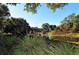 Tranquil pond view with lush vegetation and a charming gazebo in the background on a clear day at 1765 7Th St, Sarasota, FL 34236