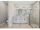 Modern bathroom with double vanity, sleek cabinetry, and glass-enclosed shower for a spa-like experience at 17676 Savory Mist Cir, Bradenton, FL 34211