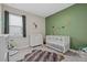 Charming Bedroom with a white crib, dinosaur themed décor, and soft carpet flooring at 17676 Savory Mist Cir, Bradenton, FL 34211