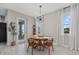 Bright dining area featuring a round table, stylish pendant lighting, and a view to the backyard at 17676 Savory Mist Cir, Bradenton, FL 34211