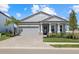 Beautiful single-story home with a brick paved driveway, grey exterior and well-manicured landscaping at 17676 Savory Mist Cir, Bradenton, FL 34211