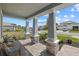 Inviting covered front porch with stone pillars, wicker chairs, and beautiful community views at 17676 Savory Mist Cir, Bradenton, FL 34211