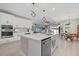 Open kitchen with stainless appliances, center island and breakfast bar, connecting to the living and dining areas at 17676 Savory Mist Cir, Bradenton, FL 34211
