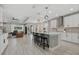 Modern kitchen featuring a large island with seating, stainless steel appliances, and an open view to the living area at 17676 Savory Mist Cir, Bradenton, FL 34211