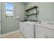 Well-organized laundry room featuring a washer, dryer, sink, and stylish decor at 17676 Savory Mist Cir, Bradenton, FL 34211
