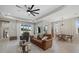 Inviting living room boasts natural light, with neutral tones, complemented by a brown leather sofa and stylish decor at 17676 Savory Mist Cir, Bradenton, FL 34211