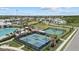 Aerial view of the sports courts featuring tennis, basketball, and playground, surrounded by lush greenery and sidewalks at 17676 Savory Mist Cir, Bradenton, FL 34211