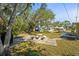 Backyard featuring stone patio, yard, mature trees, and lake views at 18399 Burkholder Cir, Port Charlotte, FL 33948