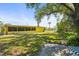 Backyard showcasing lush green grass, mature trees, and the exterior of the home at 18399 Burkholder Cir, Port Charlotte, FL 33948