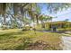 Spacious backyard with green grass, mature trees, and well-maintained landscaping at 18399 Burkholder Cir, Port Charlotte, FL 33948