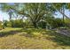 Spacious backyard featuring a large tree providing ample shade and two outdoor chairs at 18399 Burkholder Cir, Port Charlotte, FL 33948