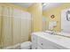 Well-lit bathroom featuring a mirror, a white sink, and a bathtub with a shower and decorated shower curtain at 18399 Burkholder Cir, Port Charlotte, FL 33948