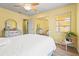 Comfortable bedroom with a white bed, bright yellow walls, and a mirrored closet at 18399 Burkholder Cir, Port Charlotte, FL 33948